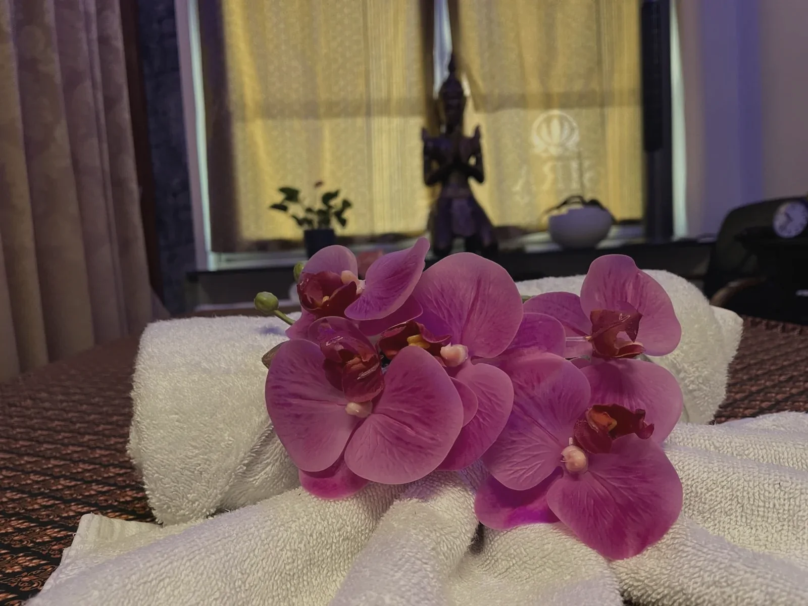 Orchideen auf weißen Handtüchern auf einer Massageliege