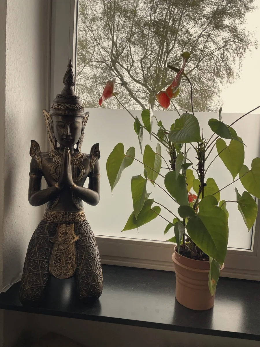 Holzfigur einer betenden Thai-Tänzerin am Fenster