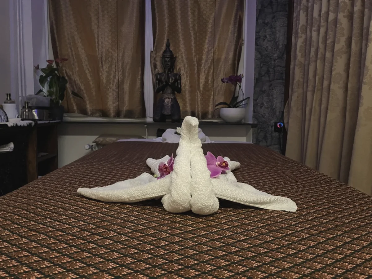 Handtuch-Schwan mit Orchideen auf der Liege